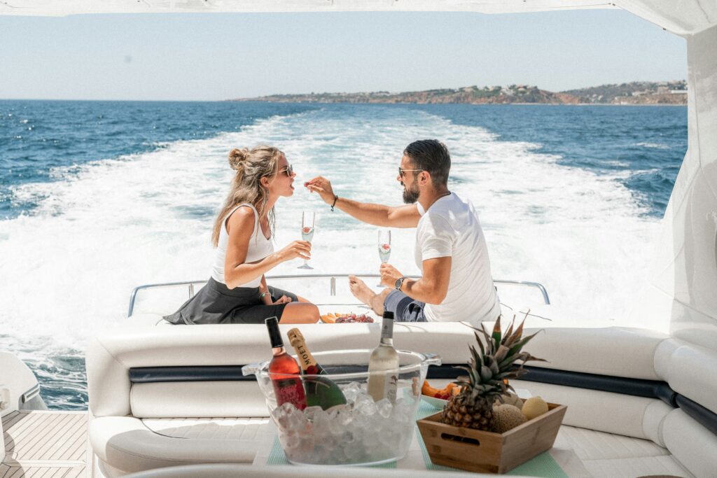 Man feeding food to a woman on a boat in the ocean