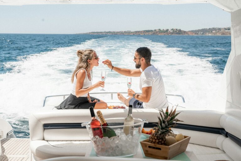 Man feeding food to a woman on a boat in the ocean